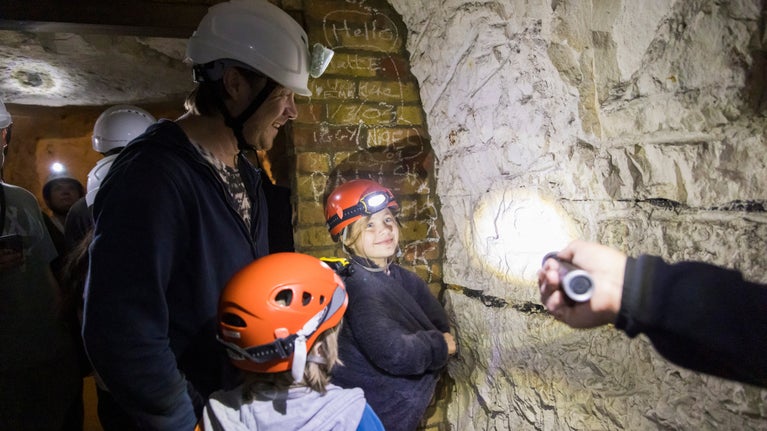 Visitors spot graffities and fossils at the Fan Bay Deep Shelter, The White Cliffs of Dover, Kent